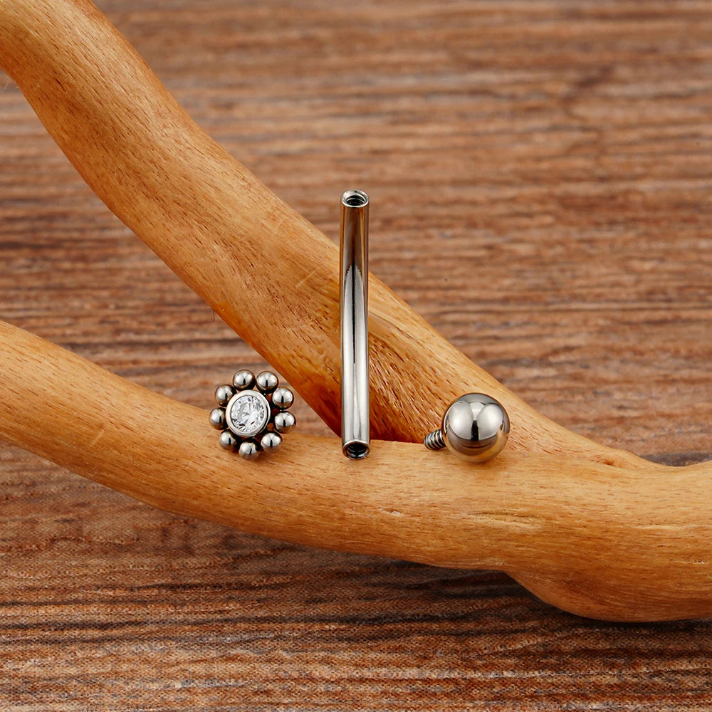 Anti-tragus ear piercing with a clear cz stone and dots in a flower shape short curved barbell
