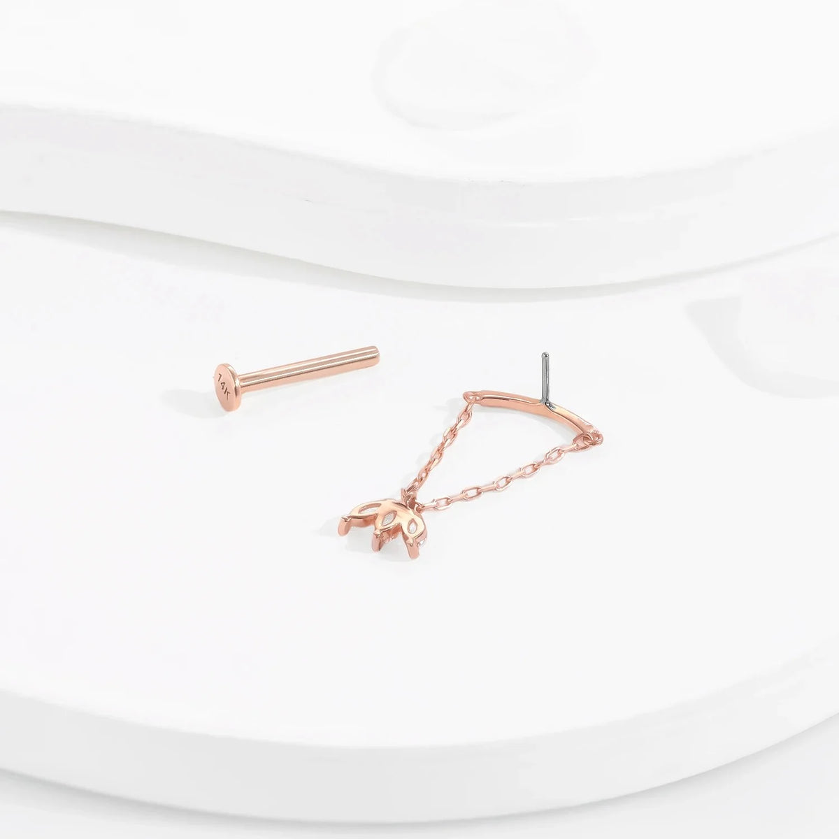 Onzichtbare Helix piercing 14k roségoud met een ketting en een bungelende Floating Helix oorbelknop