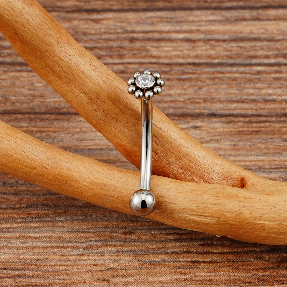 Anti-tragus ear piercing with a clear cz stone and dots in a flower shape short curved barbell