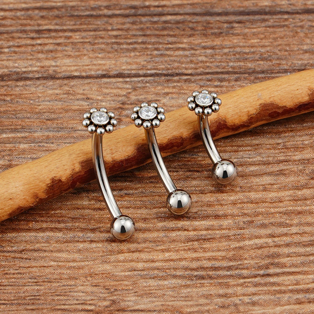 Anti-tragus ear piercing with a clear cz stone and dots in a flower shape short curved barbell