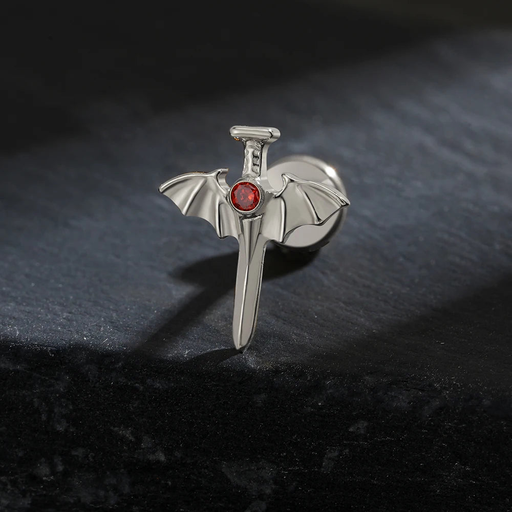 Sword ear piercing with bat wings and a red stone made of titanium halloween jewelry